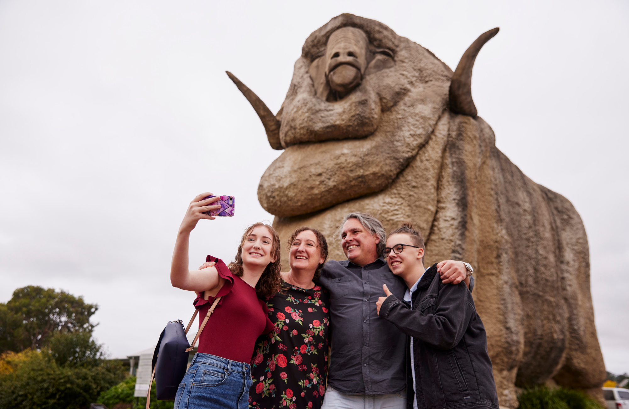 family of four people standing in front of big Marino statue in Goulburn taking a selfie photo